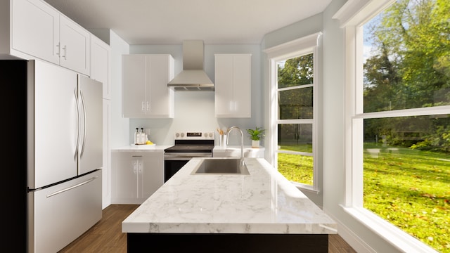 kitchen featuring wall chimney exhaust hood, sink, white cabinets, and stainless steel appliances