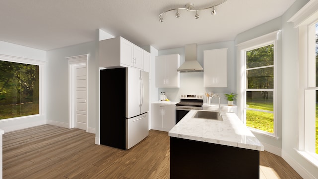 kitchen with fridge, sink, white cabinets, stainless steel range with electric cooktop, and wall chimney range hood