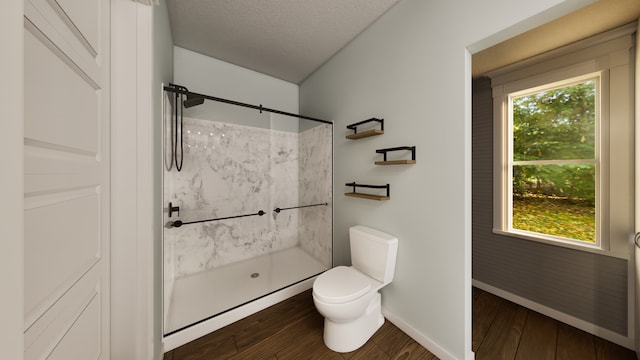 bathroom featuring toilet, a shower, hardwood / wood-style floors, and a healthy amount of sunlight