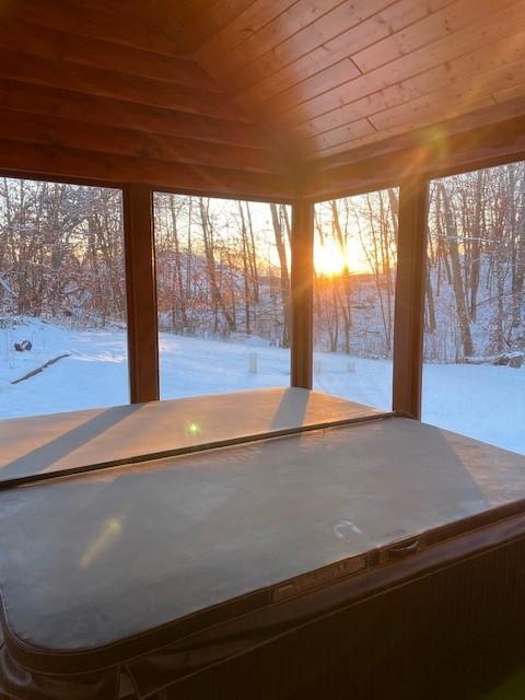 unfurnished sunroom with wooden ceiling, plenty of natural light, and vaulted ceiling