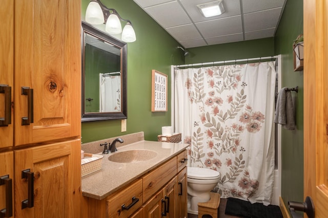 bathroom with toilet, a paneled ceiling, and vanity