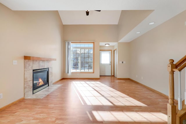 unfurnished living room featuring a tiled fireplace and light hardwood / wood-style floors