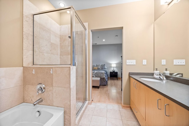 bathroom featuring shower with separate bathtub, vanity, and tile patterned flooring