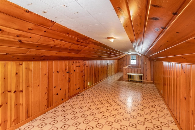 additional living space featuring lofted ceiling, radiator, wood ceiling, and wood walls