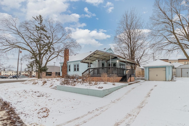 view of front of home featuring a garage, covered porch, and a shed