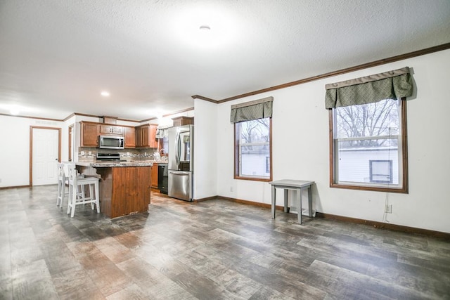 kitchen with stainless steel appliances, a kitchen island, a kitchen bar, and dark hardwood / wood-style flooring