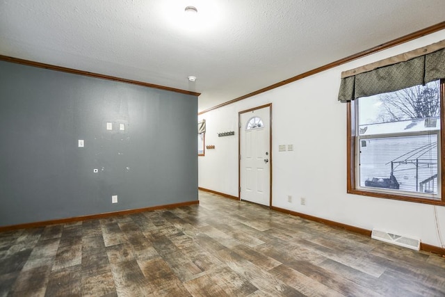 foyer featuring ornamental molding, dark wood-type flooring, and a textured ceiling