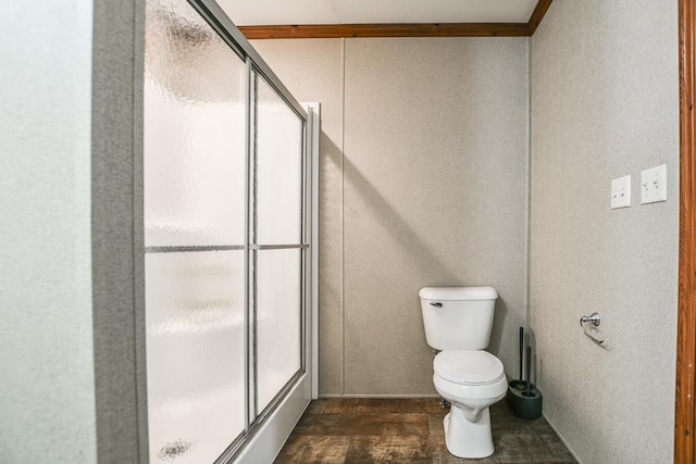 bathroom with ornamental molding, toilet, and walk in shower