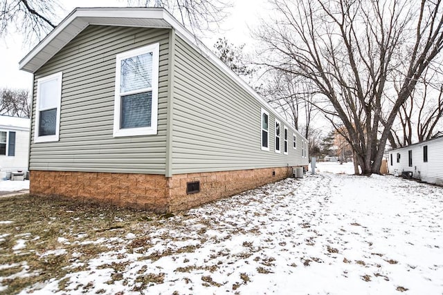 snow covered property featuring central AC