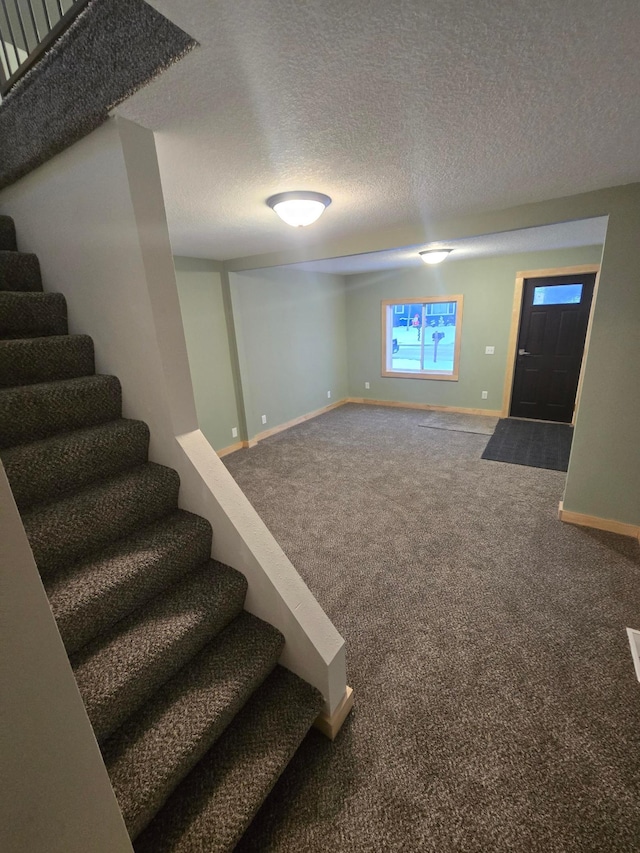 basement featuring carpet and a textured ceiling