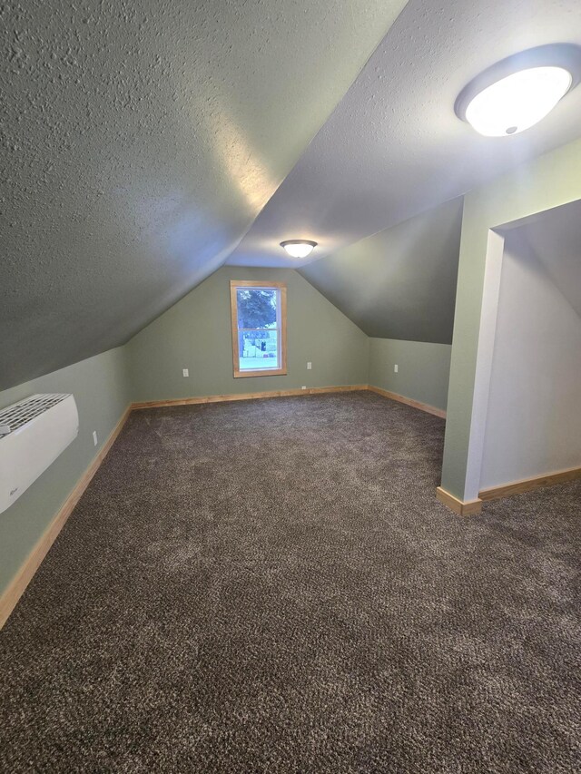 bonus room with vaulted ceiling, a textured ceiling, and carpet floors