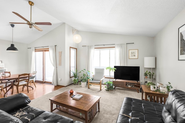 carpeted living room with a textured ceiling, ceiling fan, and high vaulted ceiling