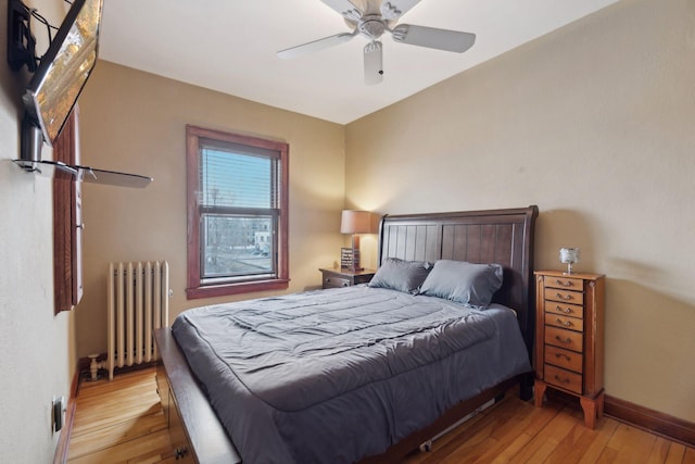 bedroom with radiator, ceiling fan, and light hardwood / wood-style flooring