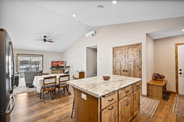 kitchen featuring stainless steel refrigerator, lofted ceiling, a center island, ceiling fan, and dark wood-type flooring