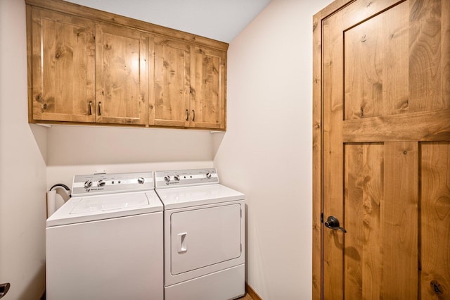 laundry room featuring washer and clothes dryer and cabinets