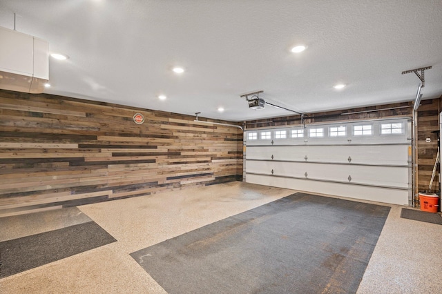 garage with a garage door opener and wooden walls