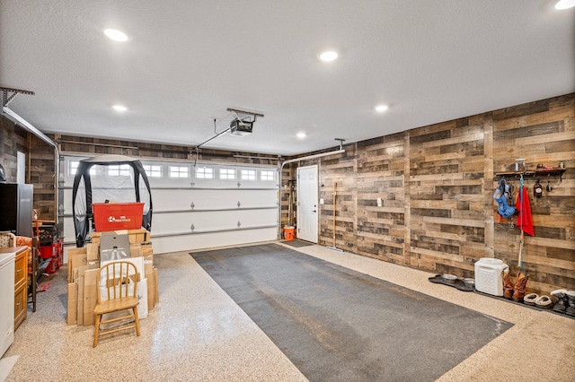 garage featuring a garage door opener and wooden walls