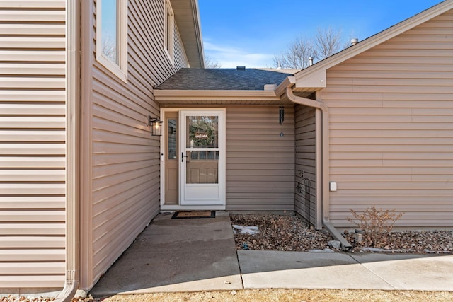 property entrance with a shingled roof