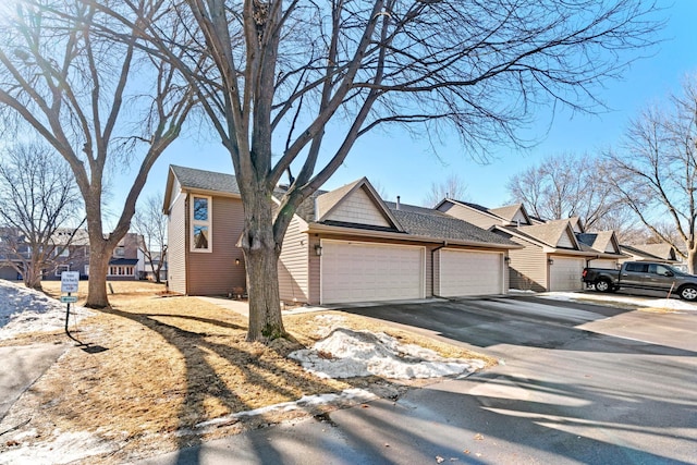 view of front of property featuring a garage, driveway, and a residential view