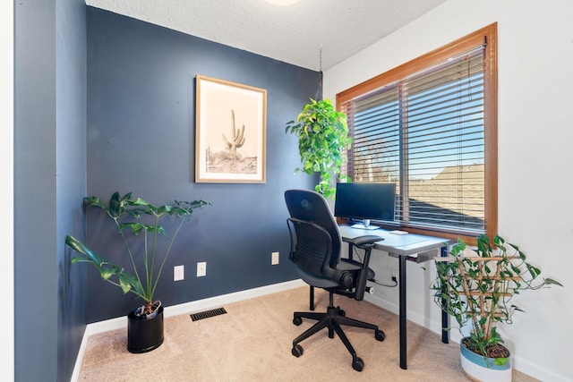 office area featuring carpet floors, baseboards, visible vents, and a textured ceiling