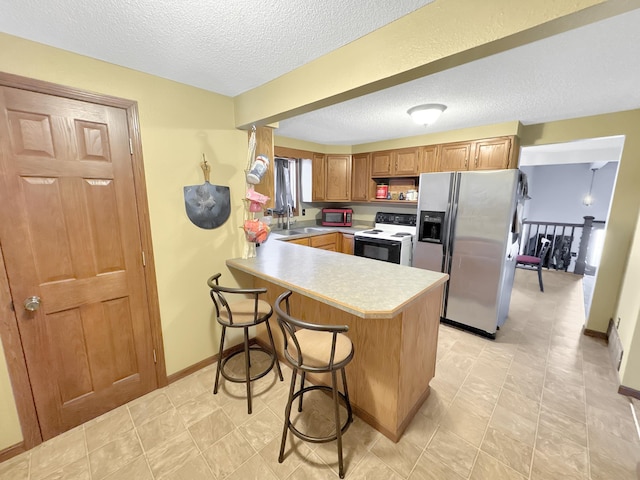 kitchen featuring kitchen peninsula, stainless steel refrigerator with ice dispenser, a kitchen breakfast bar, electric range oven, and sink