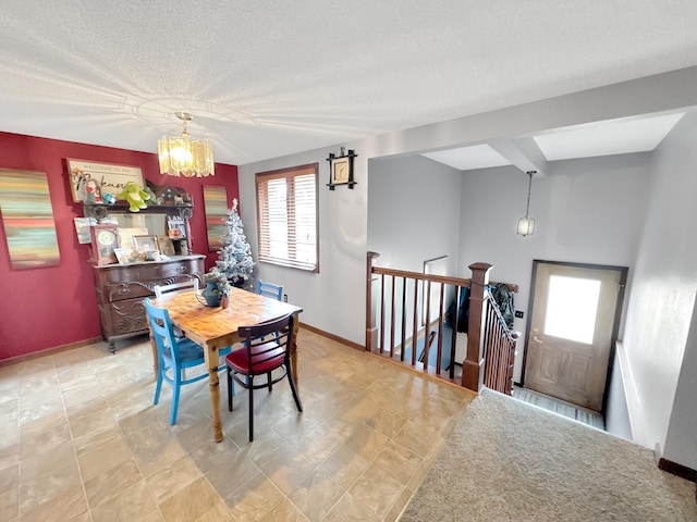 dining room with a textured ceiling, beam ceiling, and a notable chandelier