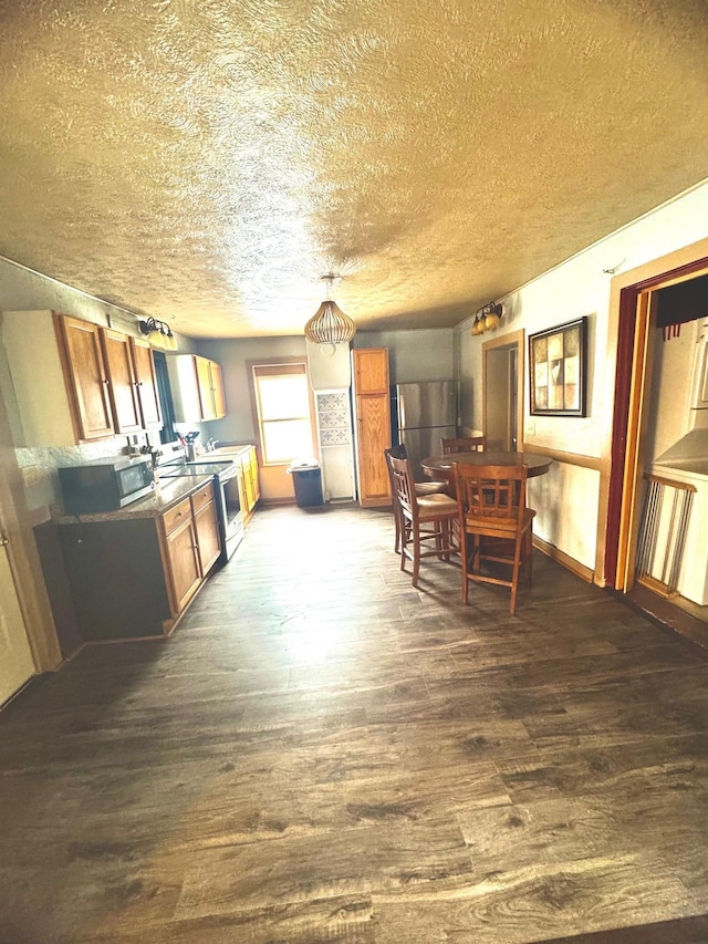 dining area with dark hardwood / wood-style floors and a textured ceiling