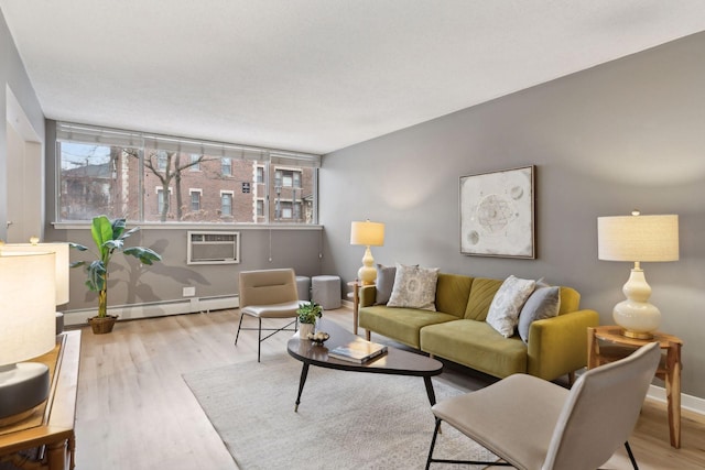 living room featuring a baseboard radiator, a wall unit AC, and light hardwood / wood-style floors