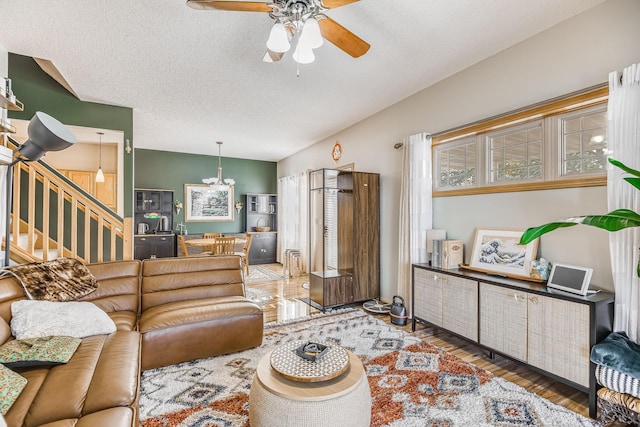 living room featuring a textured ceiling, ceiling fan, and hardwood / wood-style flooring