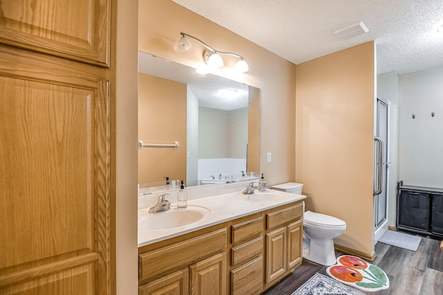 full bathroom with separate shower and tub, vanity, toilet, wood-type flooring, and a textured ceiling