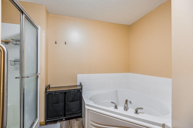 bathroom featuring hardwood / wood-style flooring, a textured ceiling, and independent shower and bath