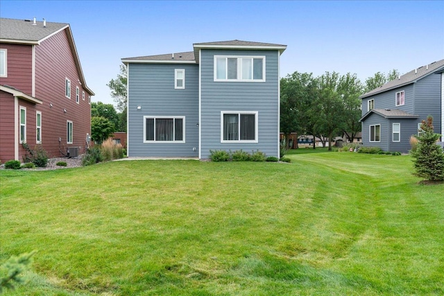 back of property with a lawn and central air condition unit