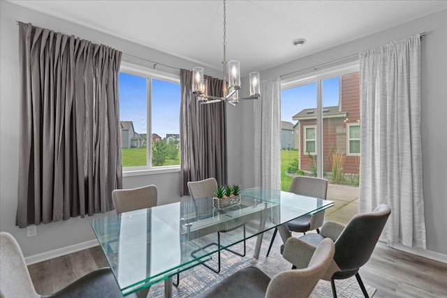 dining area with a chandelier, visible vents, light wood-style flooring, and baseboards