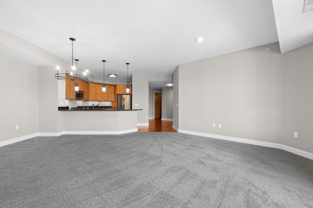 unfurnished living room with light colored carpet and an inviting chandelier