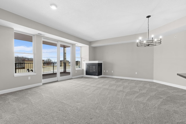 unfurnished living room with a notable chandelier and light carpet