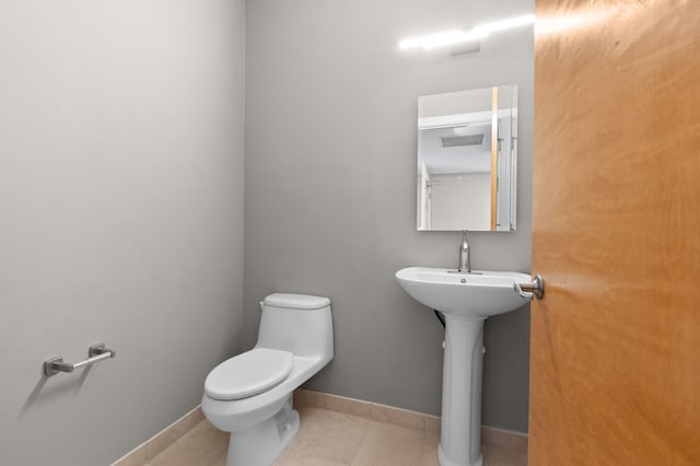 bathroom with sink, toilet, and tile patterned floors