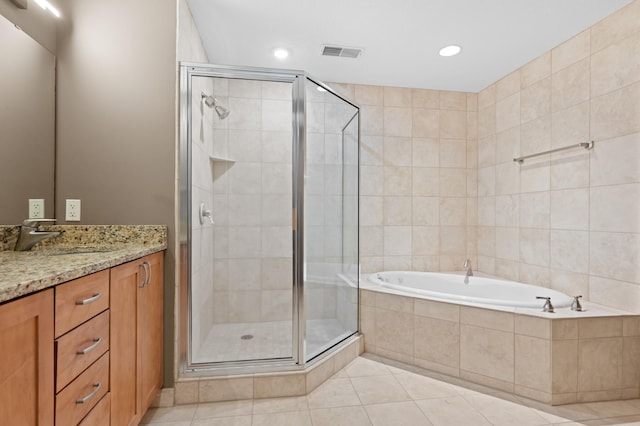 bathroom with vanity, tile patterned floors, tile walls, and separate shower and tub