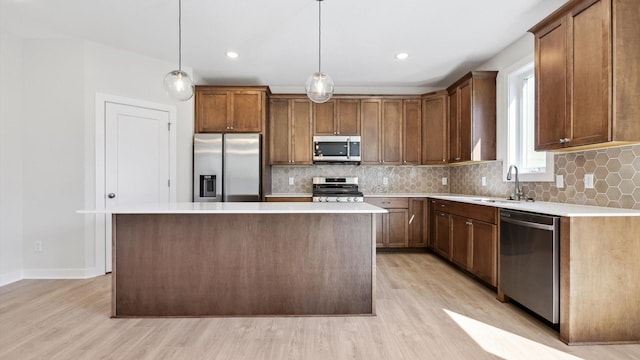 kitchen featuring decorative light fixtures, a center island, and appliances with stainless steel finishes