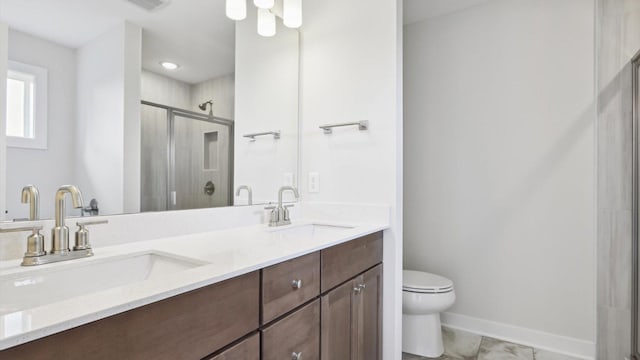 bathroom with an enclosed shower, vanity, and toilet