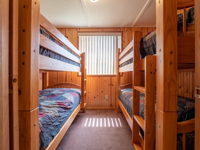 bedroom with carpet floors and wood walls