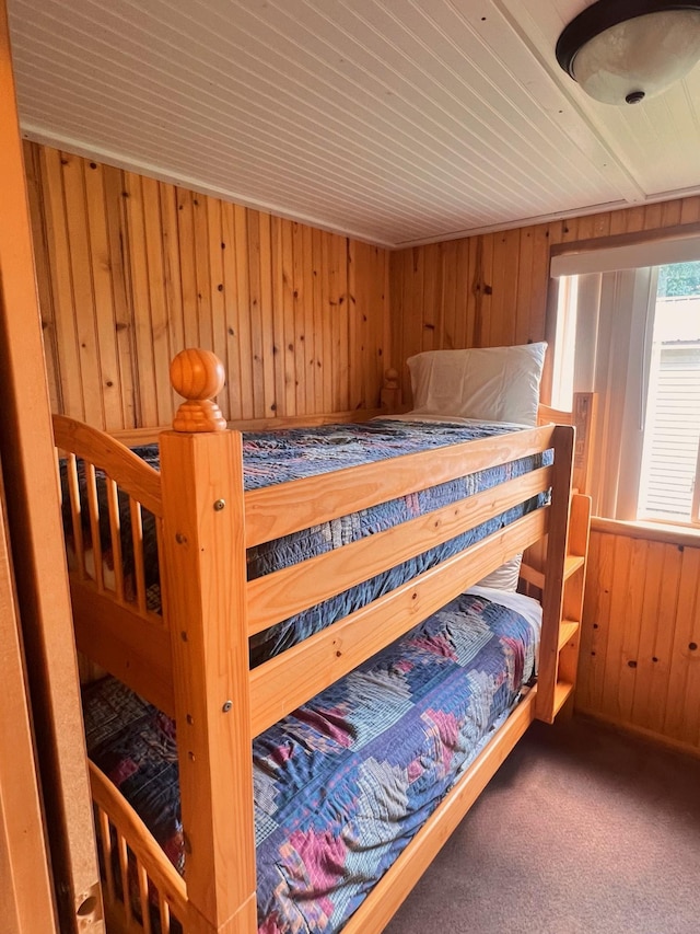 bedroom with wood walls and carpet flooring