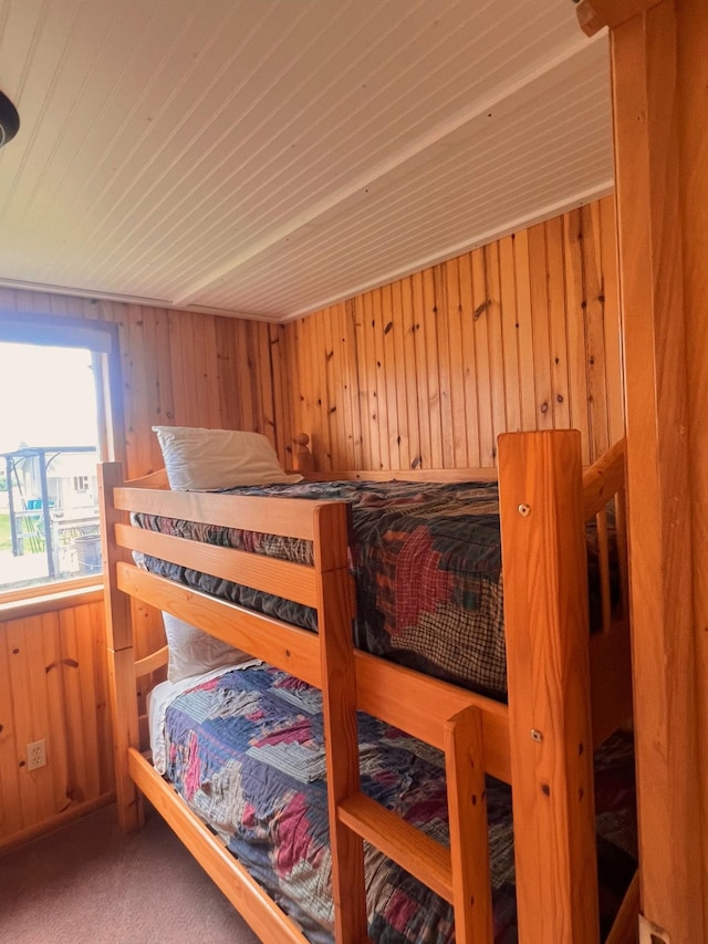 bedroom featuring carpet flooring and wood walls