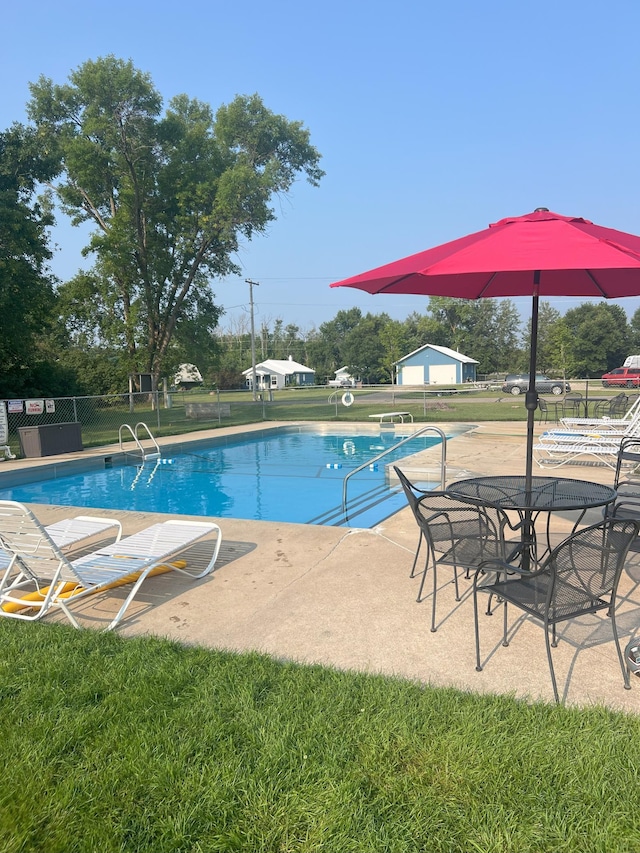 view of pool featuring a lawn and a patio