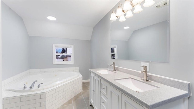 bathroom featuring a relaxing tiled tub, tile patterned floors, lofted ceiling, and vanity