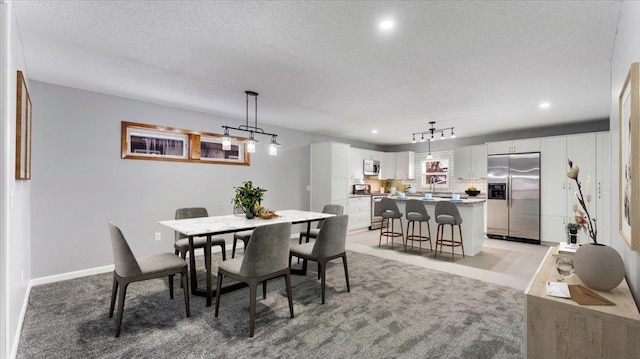 carpeted dining space featuring a textured ceiling