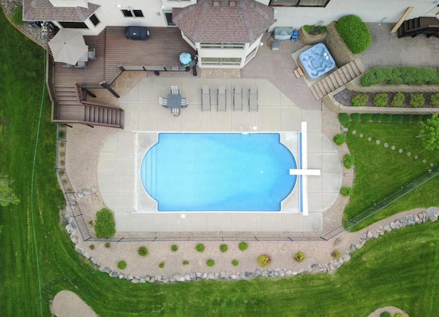 view of swimming pool featuring a yard and a diving board