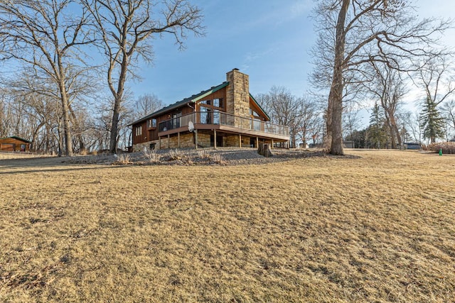 back of house featuring a deck and a lawn