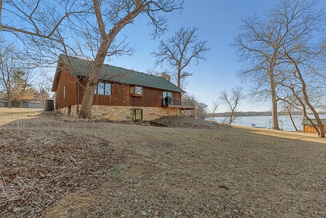 view of home's exterior featuring a deck with water view