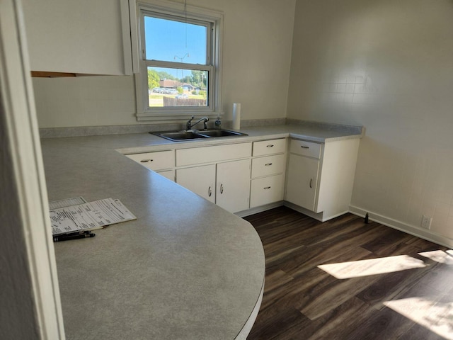 kitchen with white cabinets, dark wood-type flooring, and sink