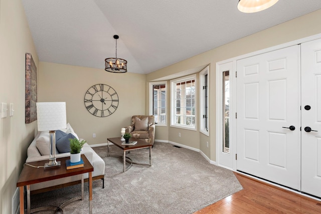 entrance foyer with an inviting chandelier, hardwood / wood-style floors, and vaulted ceiling